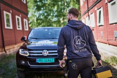Vaktmester som går med ryggen til mot bilen.